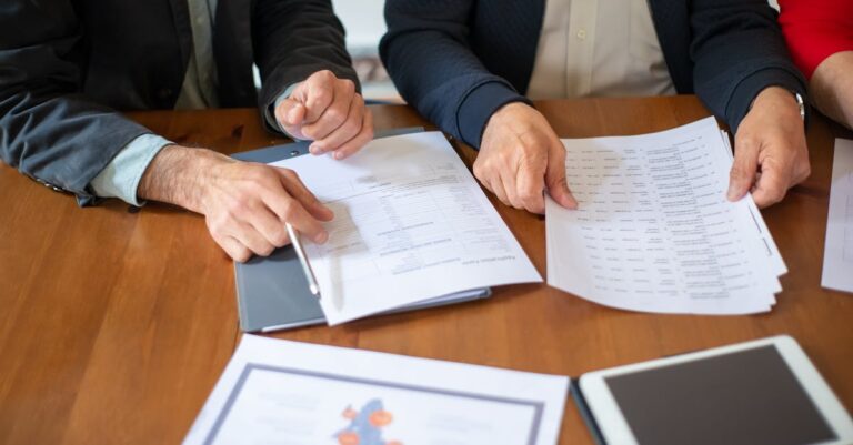 Two business professionals discussing and reviewing documents during a meeting.